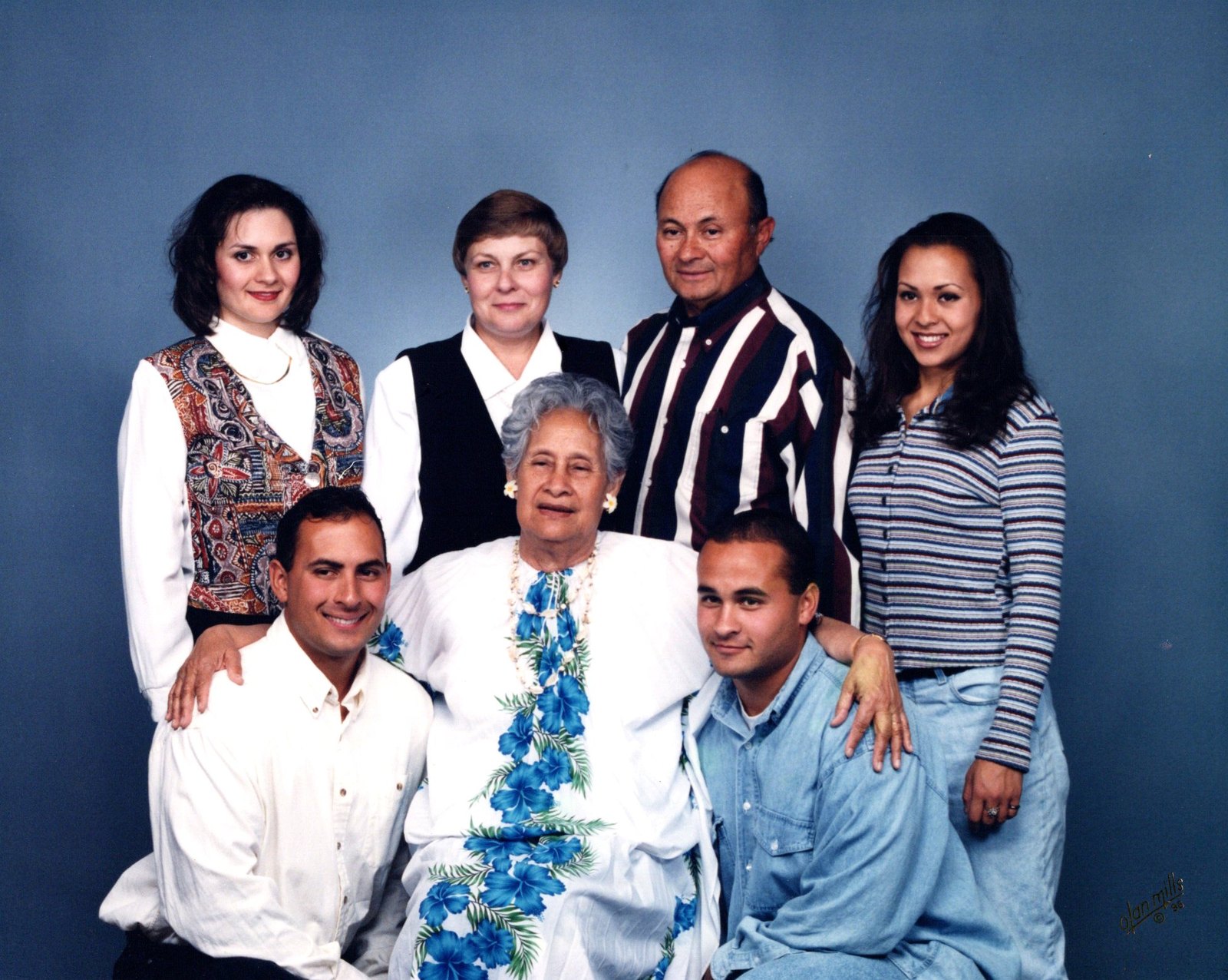 Studio family portrait with Foalima, his wife, their children and Grandma Suitofaga seated in the center wearing a white dress with blue flowers.
